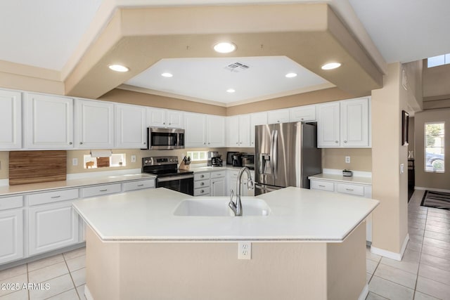 kitchen featuring sink, light tile patterned floors, stainless steel appliances, a large island, and white cabinets