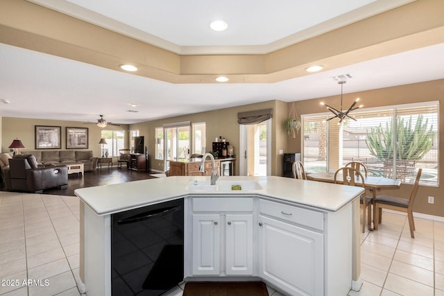 kitchen with sink, light tile patterned floors, dishwasher, white cabinetry, and decorative light fixtures