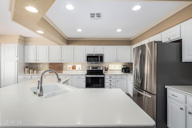 kitchen with appliances with stainless steel finishes, sink, and white cabinets