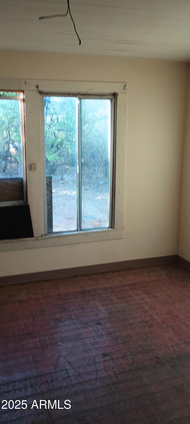 unfurnished room featuring baseboards