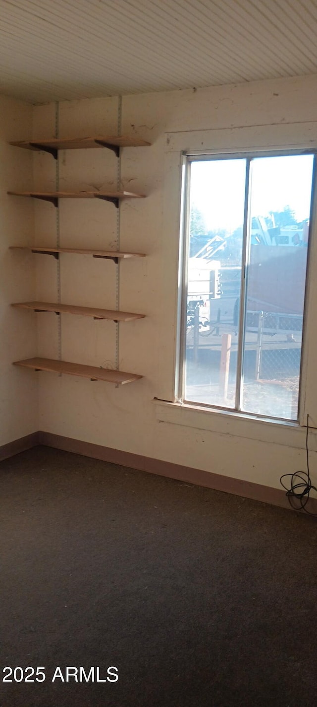 unfurnished room with baseboards