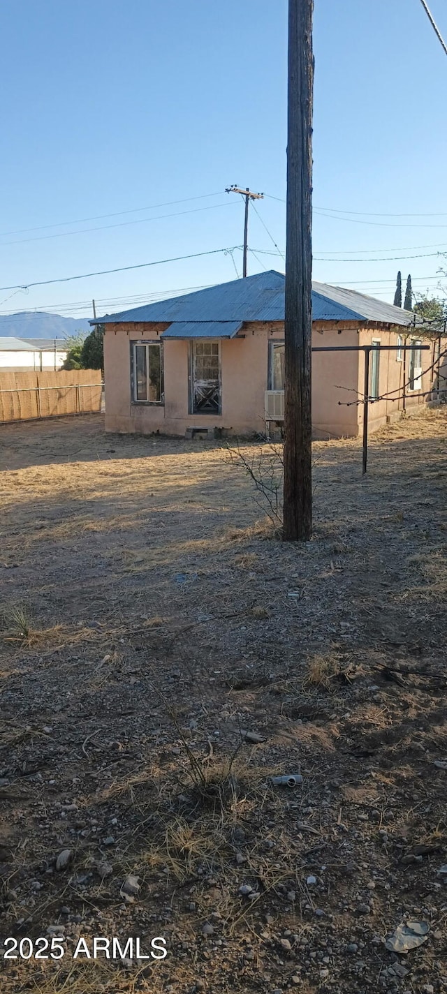 view of front of home with stucco siding and fence