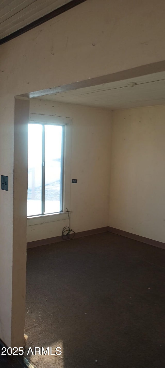 unfurnished room with baseboards