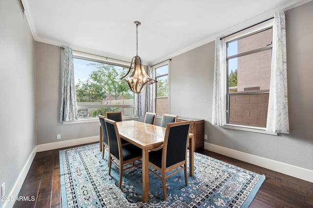 dining space featuring dark wood-style floors, an inviting chandelier, and ornamental molding