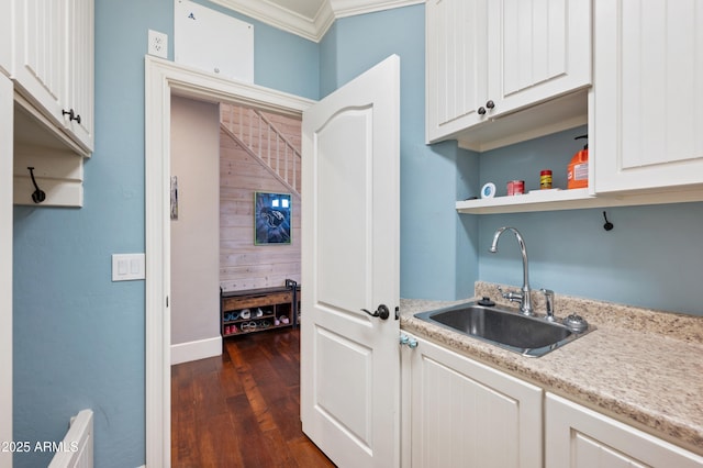 kitchen with light countertops, crown molding, dark wood-type flooring, a sink, and open shelves