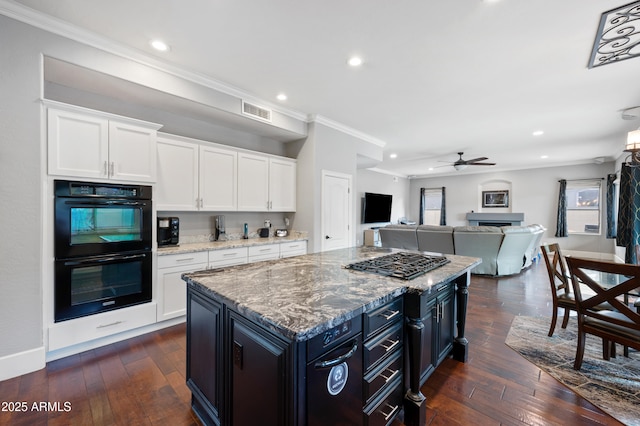 kitchen featuring dobule oven black, ornamental molding, visible vents, and dark wood finished floors