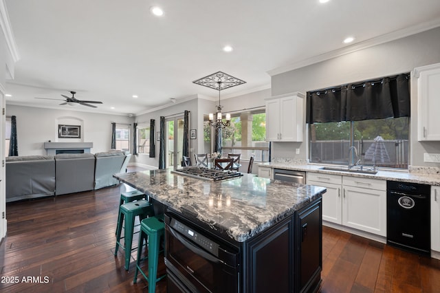 kitchen with white cabinets, a sink, light stone countertops, and dark wood finished floors