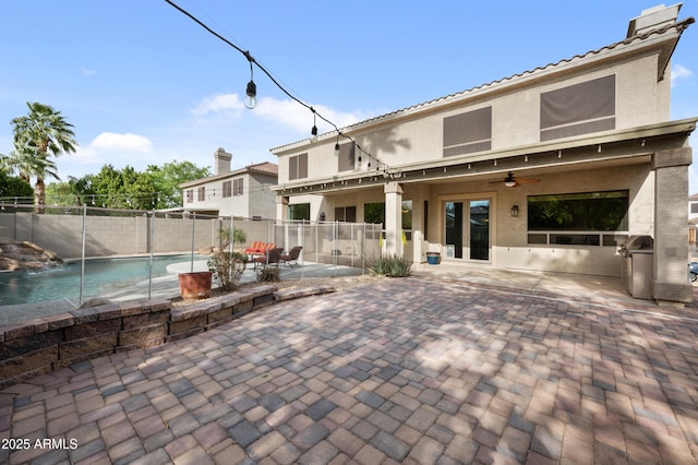 exterior space with a fenced backyard, a fenced in pool, grilling area, and a ceiling fan