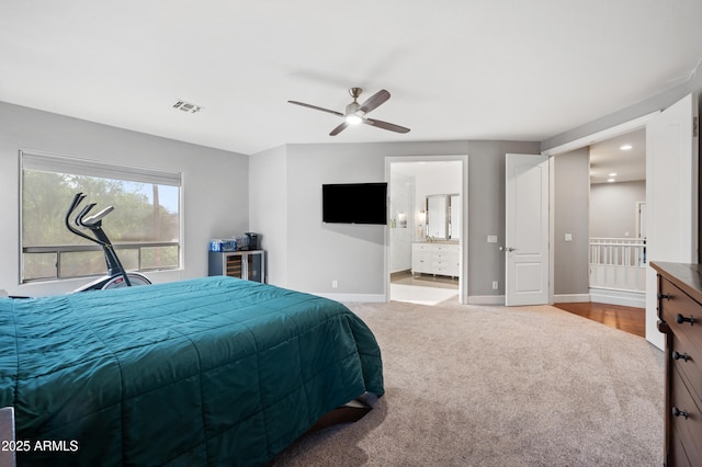 carpeted bedroom with connected bathroom, baseboards, ceiling fan, and visible vents