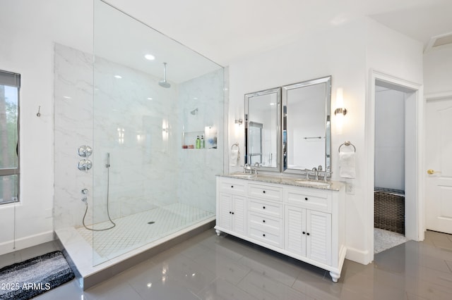 bathroom featuring double vanity, tile patterned floors, a sink, and a marble finish shower