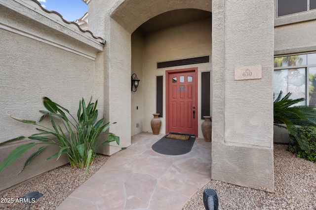 doorway to property featuring stucco siding