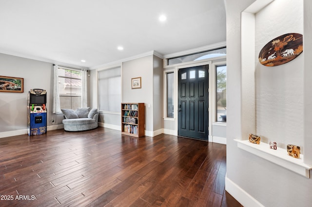 foyer with baseboards, wood finished floors, and crown molding