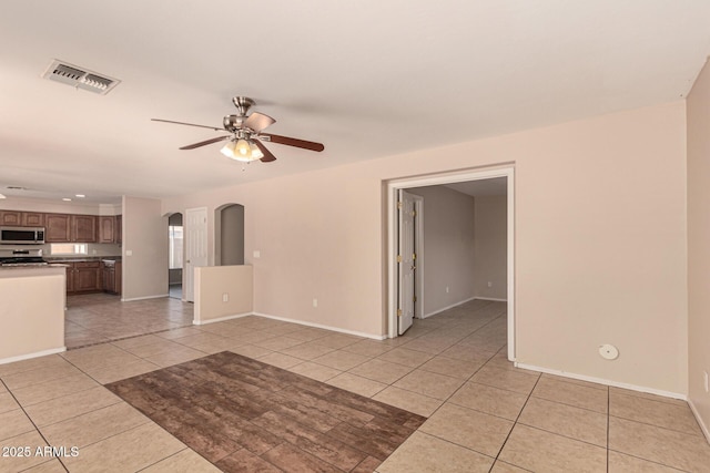 interior space with light tile patterned floors and ceiling fan