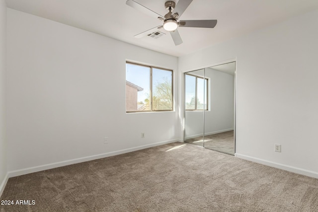 unfurnished bedroom featuring ceiling fan, a closet, and carpet