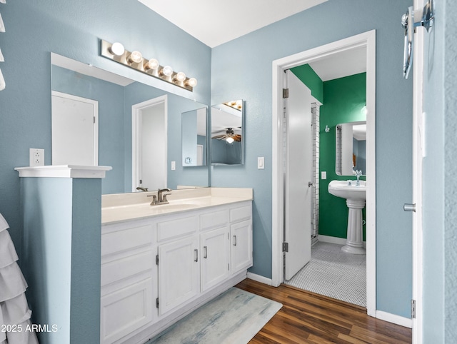 7726 W Cameron Dr, Peoria, AZ 85345 - bathroom with a sink, ceiling fan, wood finished floors, and baseboards