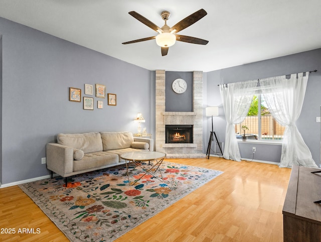 7726 W Cameron Dr, Peoria, AZ 85345 - living area featuring wood finished floors, ceiling fan, a fireplace, and baseboards