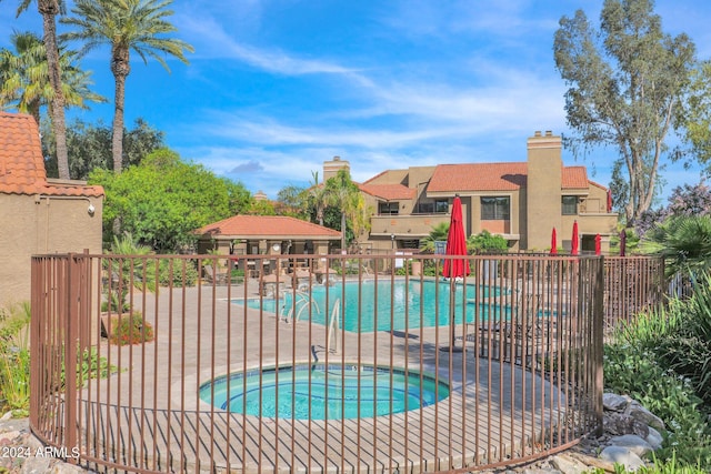 view of swimming pool featuring a hot tub and a patio area