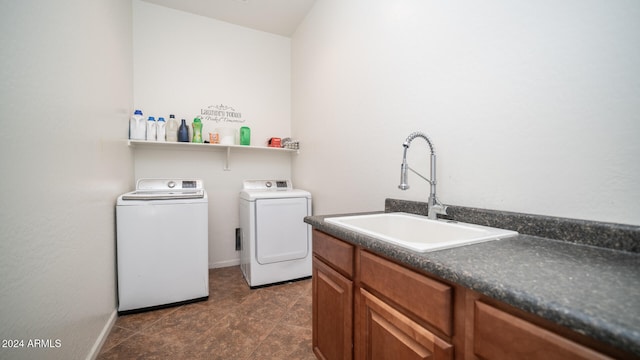 laundry room featuring washer and dryer, sink, and dark tile patterned floors