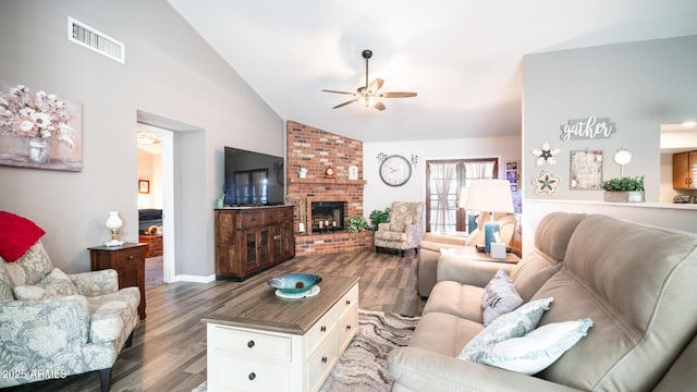 living room featuring ceiling fan, dark wood-type flooring, lofted ceiling, and a brick fireplace