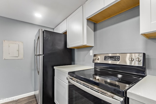kitchen with dark wood-style flooring, light countertops, white cabinetry, electric panel, and stainless steel appliances