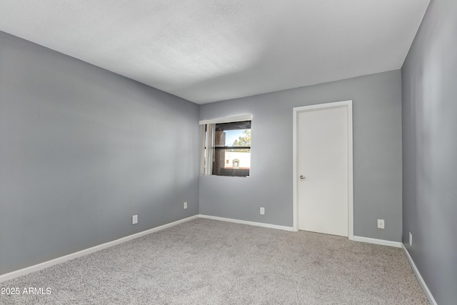 carpeted spare room with baseboards