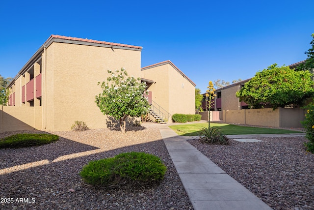 view of home's exterior with fence and stucco siding