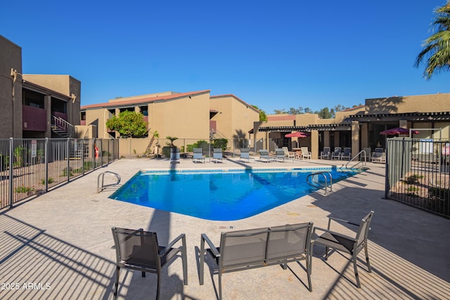 community pool with a patio and fence