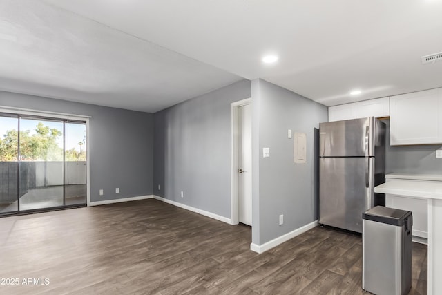 kitchen featuring light countertops, baseboards, white cabinets, freestanding refrigerator, and dark wood-type flooring