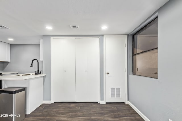 laundry room featuring visible vents, dark wood-style floors, and a sink