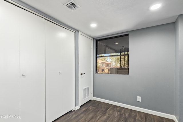 unfurnished bedroom with visible vents, a closet, baseboards, recessed lighting, and dark wood finished floors