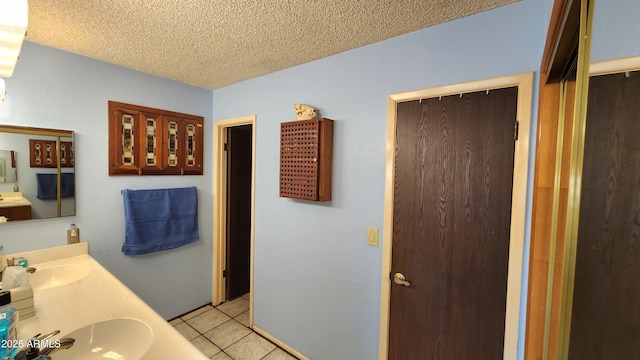 bathroom featuring vanity, tile patterned floors, and a textured ceiling