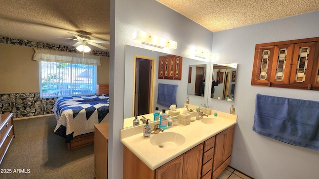 bathroom with ceiling fan, vanity, and a textured ceiling