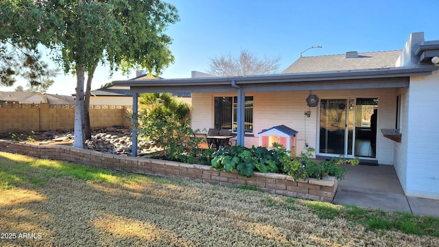 rear view of house with a patio and a lawn