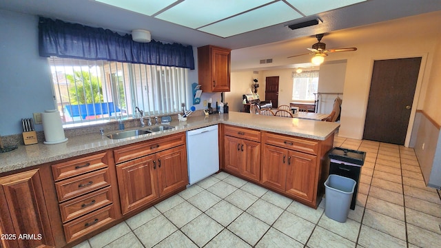 kitchen featuring white dishwasher, kitchen peninsula, sink, and light tile patterned floors