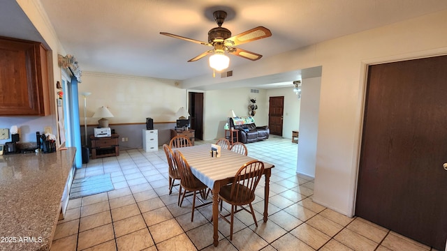 tiled dining space with ceiling fan