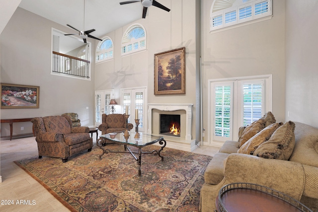 living room with light hardwood / wood-style floors, a high ceiling, and ceiling fan