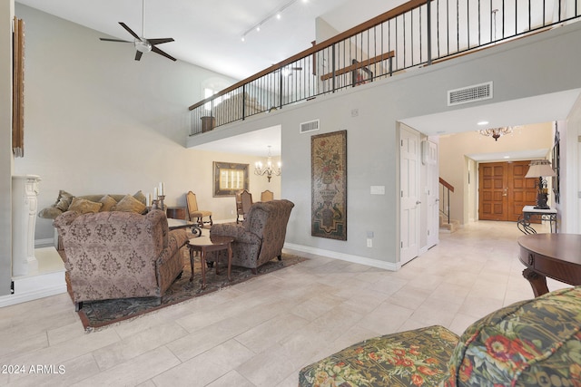 living room with ceiling fan with notable chandelier, track lighting, and high vaulted ceiling