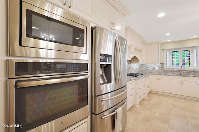 kitchen featuring light stone countertops, stainless steel appliances, sink, and white cabinets