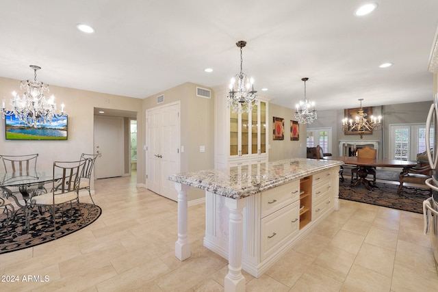 kitchen featuring light stone countertops, a kitchen breakfast bar, hanging light fixtures, and a center island