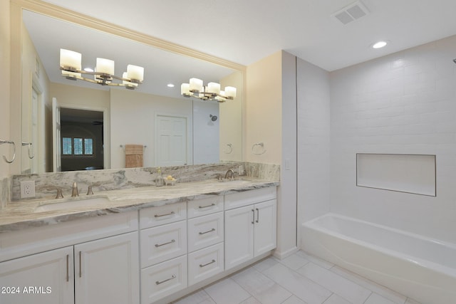 bathroom with a chandelier, tiled shower / bath combo, tile patterned floors, and vanity