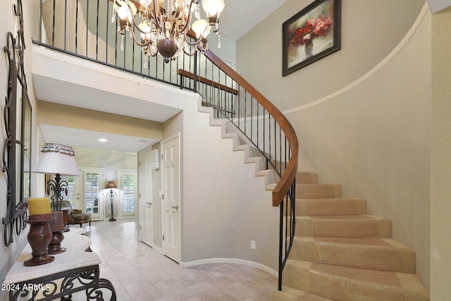 stairs with an inviting chandelier and tile patterned flooring