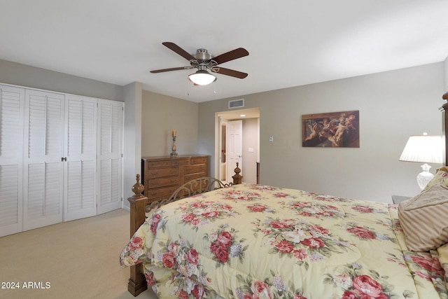 bedroom with ceiling fan, light colored carpet, and a closet