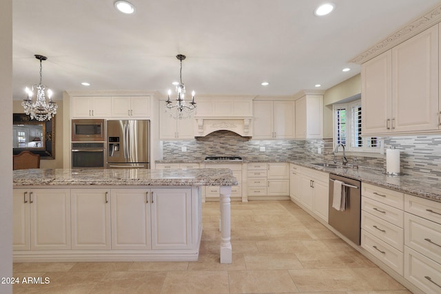 kitchen featuring stainless steel appliances, pendant lighting, and light stone counters