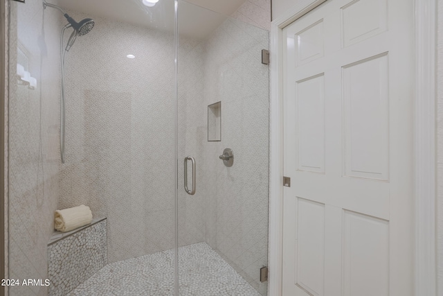 bathroom featuring a shower with door