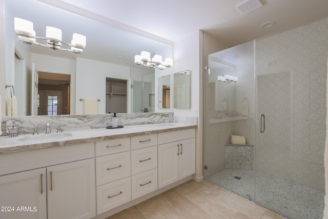 bathroom with tile patterned flooring, an enclosed shower, and vanity