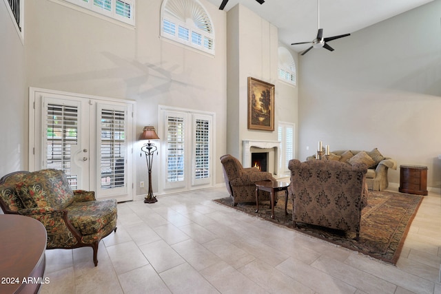 living room with ceiling fan, french doors, a high ceiling, and a healthy amount of sunlight