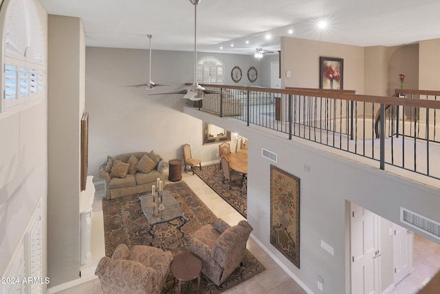 tiled living room with a wealth of natural light and ceiling fan