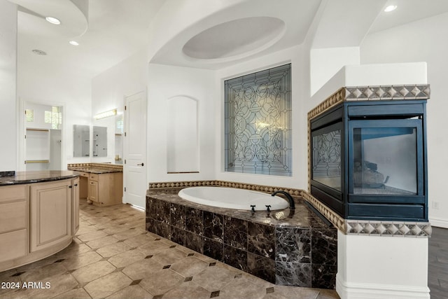 bathroom with a relaxing tiled tub and vanity