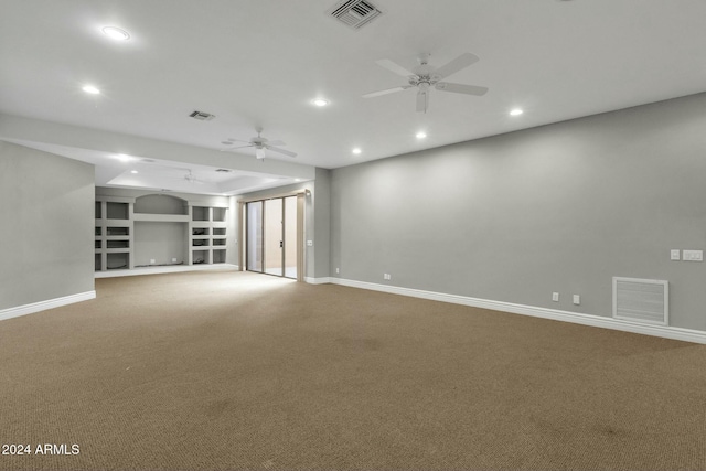 spare room featuring carpet flooring, built in features, and ceiling fan