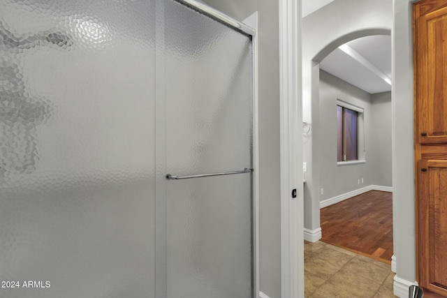 bathroom featuring tile patterned flooring and an enclosed shower